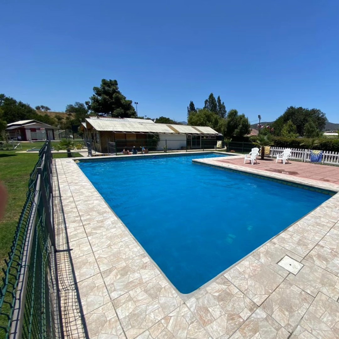 Piscina grande con agua celeste y reposeras